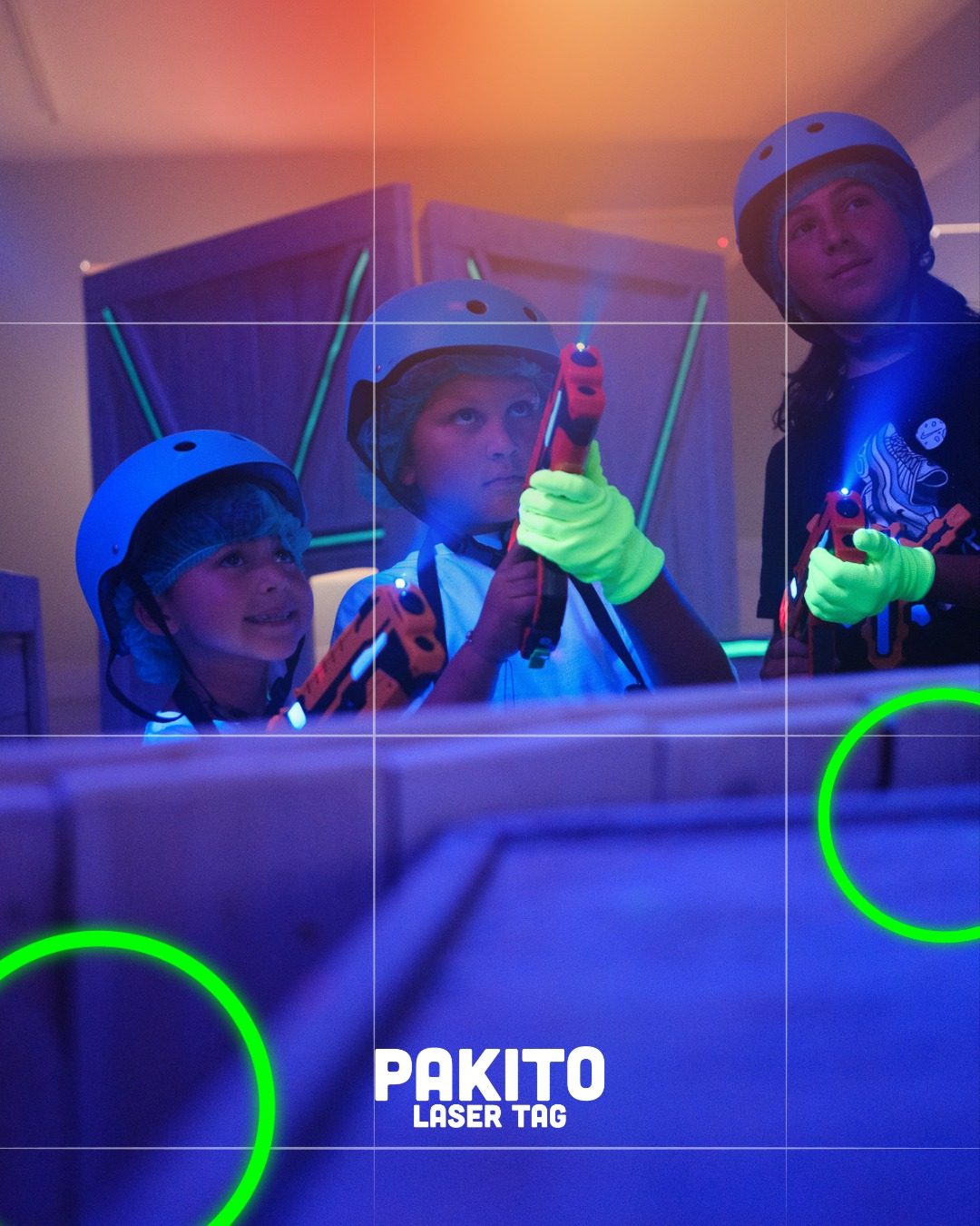 Bambini al Pakito Laser Tag con caschi UV blu, pistole laser e raggi neon nell'arena con fortini in legno