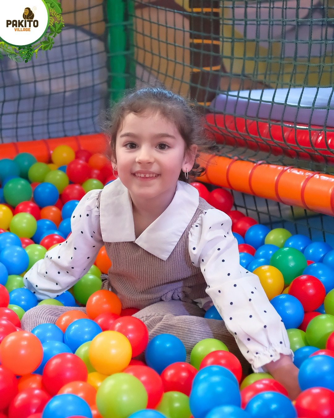 Bambina nella piscina di palline colorate del Parco Giochi al coperto del Pakito Jungle Palace