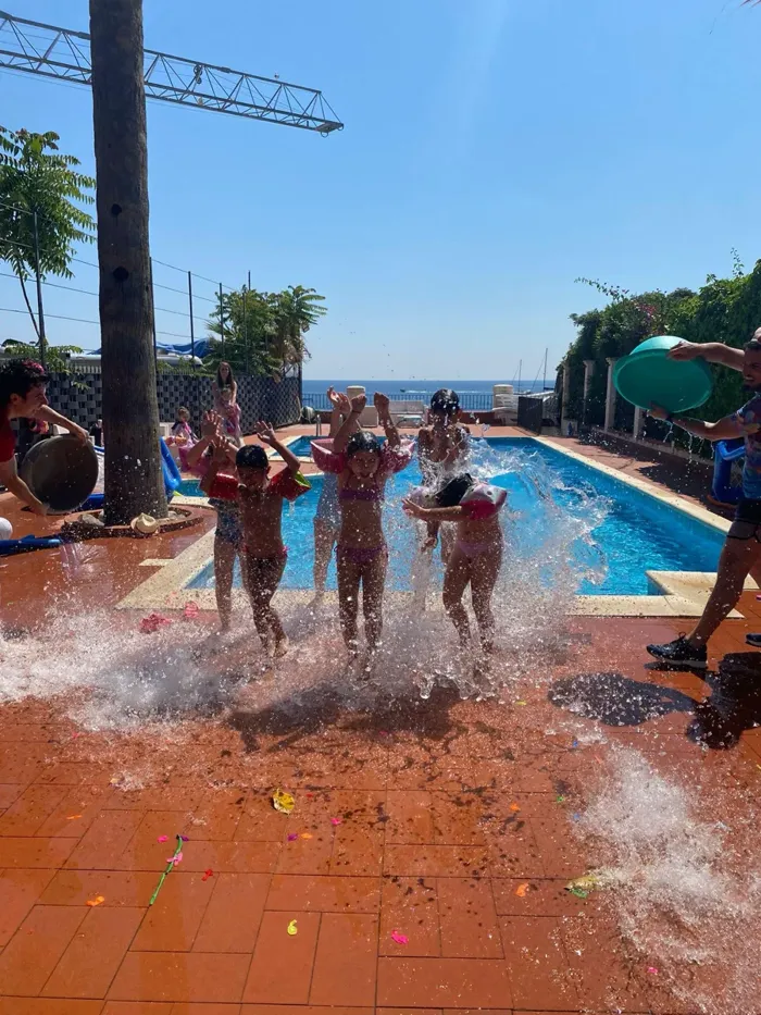 Water Party - bambini giocano con i gavettoni e l'acqua a bordo piscina